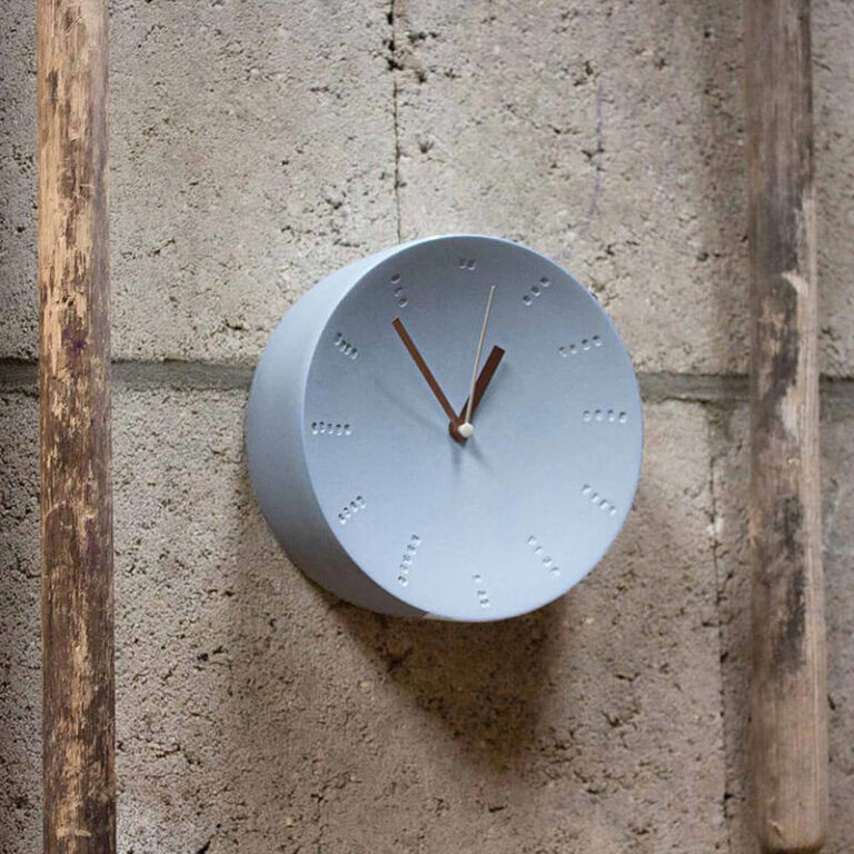 De eenvoud van het ontwerp maakt dat de porseleinen klok past in allerlei interieurs zoals ook op een wand met pure materialen.