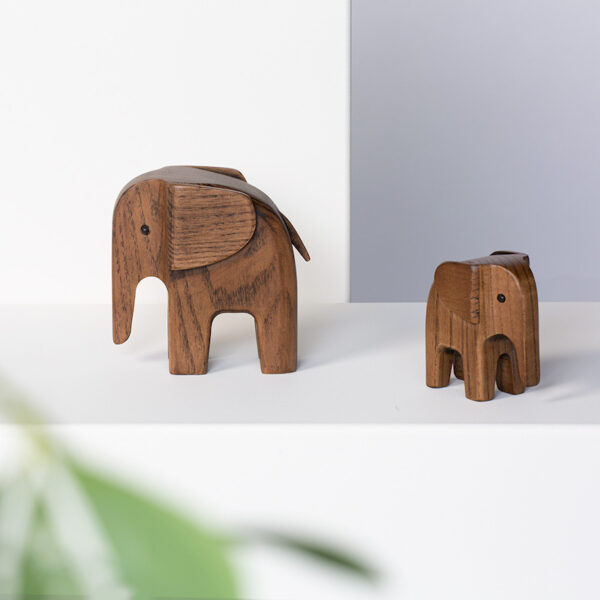 Het formaat van de houten design Baby Elephant is 75 x 40 x H77 mm. Het object is ambachtelijk gemaakt van donker gerookt essenhout.