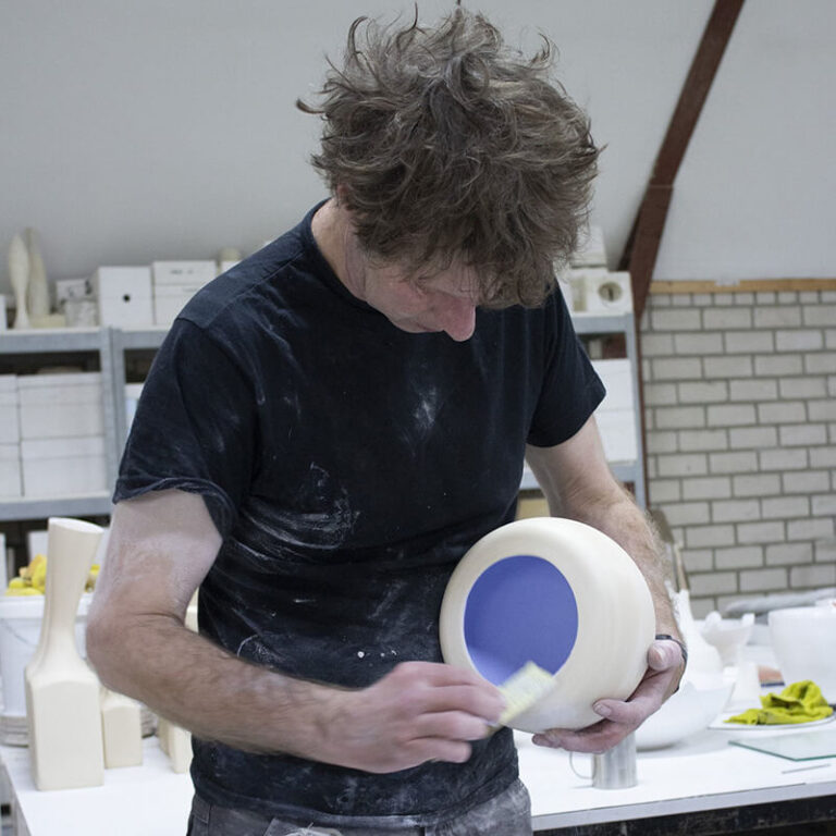 Olav Slingerland aan het werk in zijn atelier. Hij schuurt de buitenzijde van bolle Behuizingschaal.