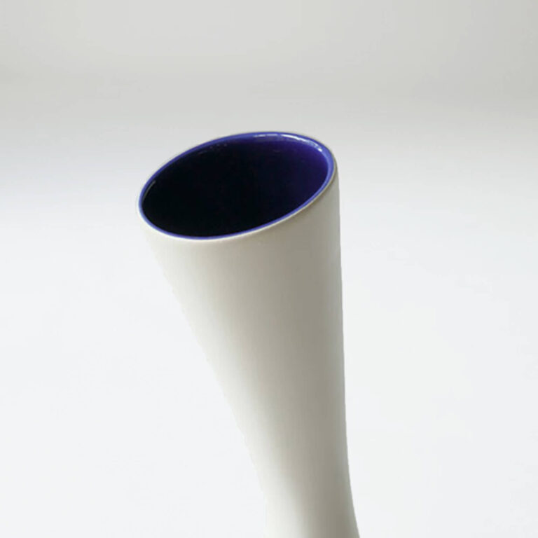 De uitlopende hals van de witte Piso design vaas heeft een opvallende kleur zoals blauw.