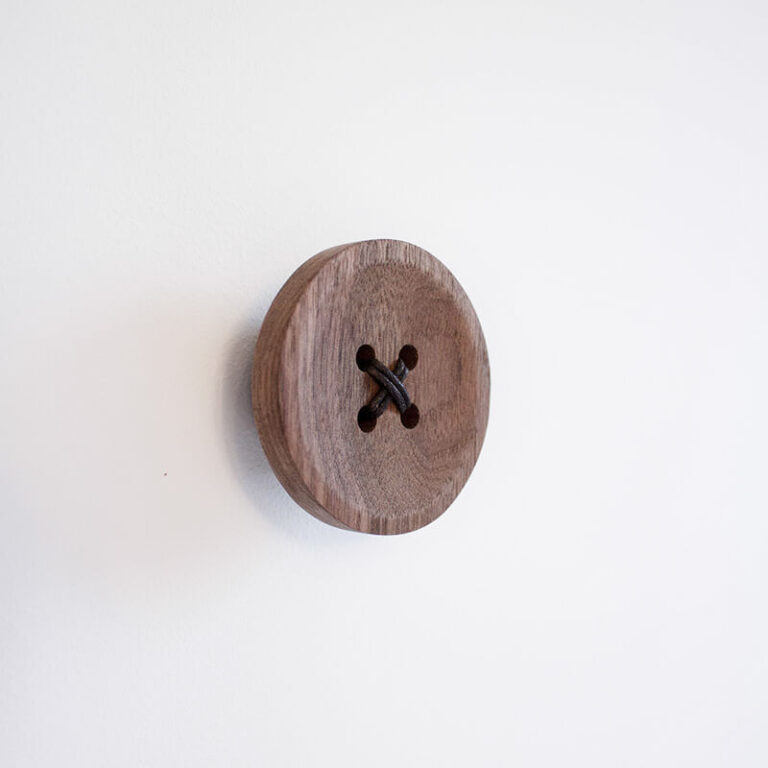 Door de 4 gaatjes van de houten Snappy knoop zit een veter van leer. Hang je mooiste kleding, tassen of sieraden aan deze design hanger