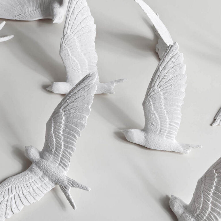 De witte zwaluwen van de Swallow klok zijn gegoten van kunsthars en daarna zijn de details met de hand verder uitgewerkt.