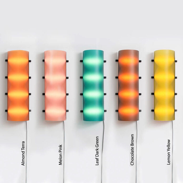 Alle kleuren van de moderne Connection Clamp Lamp van Ilse Bouwens op een rijtje. De lampen zijn hier aan en de namen van de kleuren zijn vermeld.