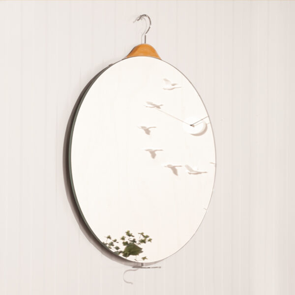 Aan de achterzijde van design spiegel Mirror Hanger is een kleerhanger bevestigd. Hiermee hang je heel eenvoudig de ronde spiegel op.