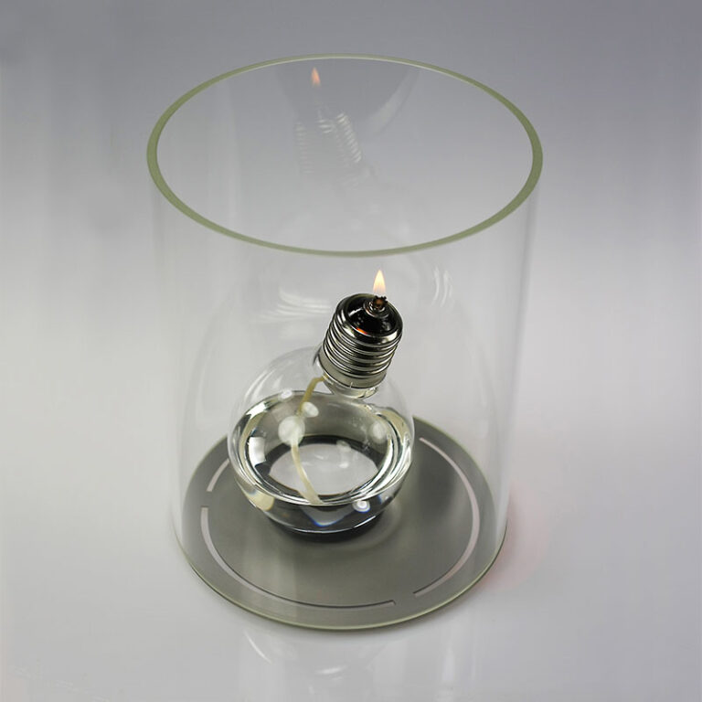 De moderne olie(gloei)lamp KonfuziLUX rust op een rubberen ring en staat in een groot windlicht van maar liefst 25 cm hoog. Deze cilinder is gemaakt van hoogwaardig, 5 mm dik, bijzonder helder Borosilicaatglas. De bodem is van RVS.