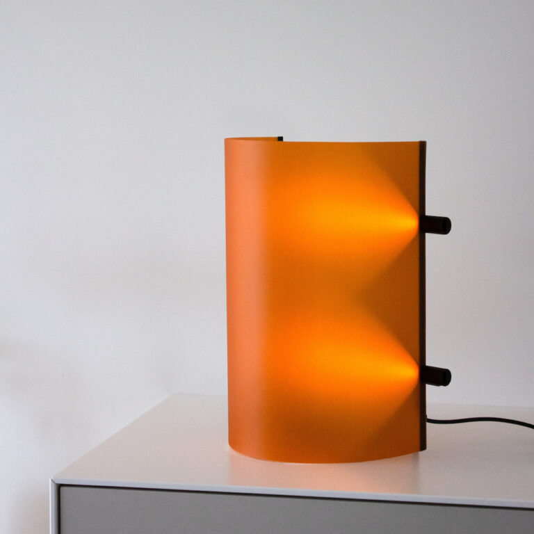 Deze design tafel- en wandlamp heeft een zeer strakke vormgeving en toch een warme uitstraling.