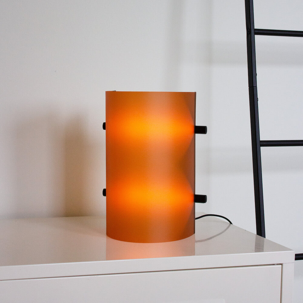 Deze design tafel- en wandlamp genaamd CCL2 is uitgevoerd met een warme terra kleurige lampenkap.