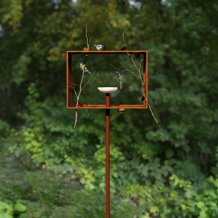 Een rechthoekig kader van cortenstaal omlijst de voerderschaal van de Framed Feeder vogelvoederschaal. Het ontwerp past in elke tuin.