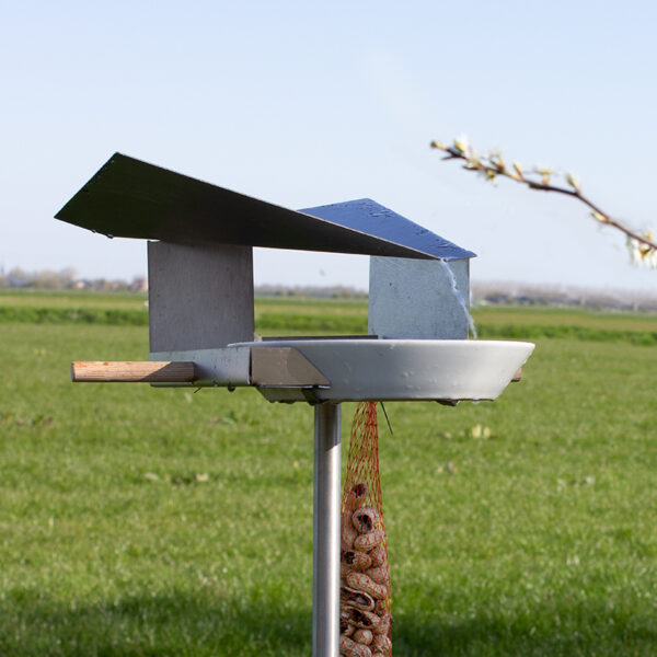 Het Waterloop vogelhuis heeft een heel bijzonder dak dat het water naar een flinke schaal geleidt.