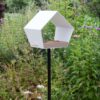 Vogelvoederhuisje Big Diamond met helder wit huisje en natuurlijke kleuren in een weelderige tuinsetting